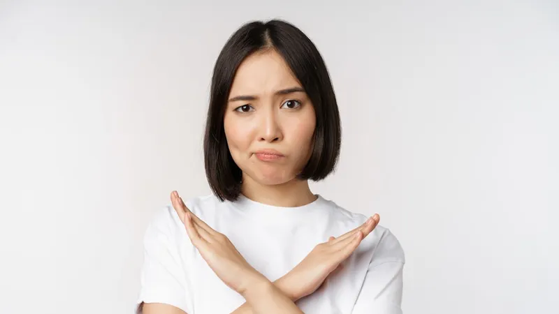 부정 표현 — 팔로 X자를 만들어 아니라고 하는 모습