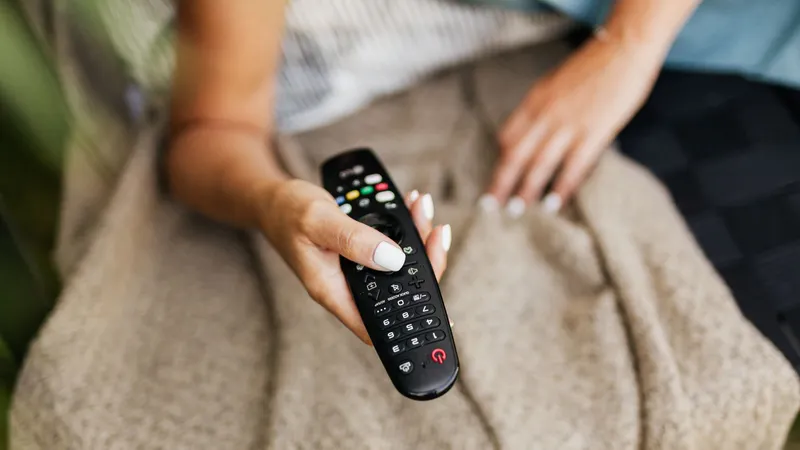 TV 리모컨을 든 손